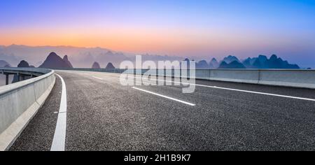 Route asphaltée vide et belles montagnes au lever du soleil à Guilin, en Chine. Banque D'Images