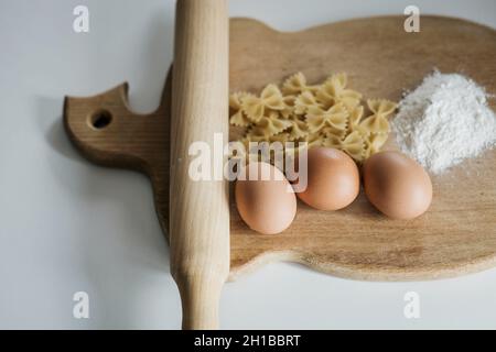 pâtes nouées à l'arc non cuites sur une planche en bois Banque D'Images