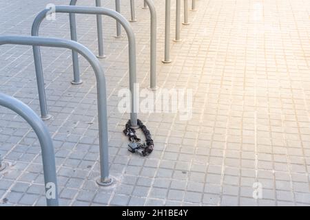 Cadenas et chaîne abandonnés dans un parking public à vélos Banque D'Images