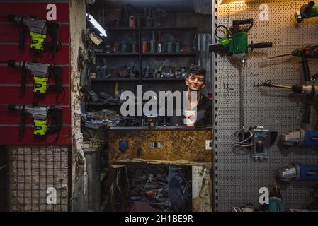 Amman, Jordanie - octobre 06 2021: Marché du centre-ville dans la capitale Amman, le jeune homme est sa boutique de pourriels de réparation Banque D'Images