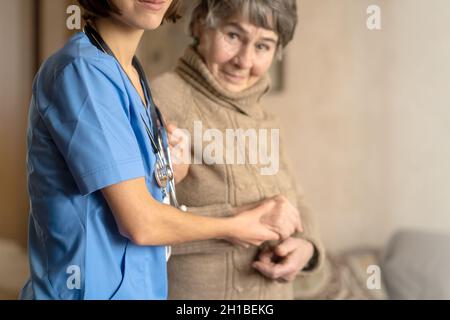 Une jeune infirmière fait preuve de soins et de professionnalisme par rapport à une femme âgée. Banque D'Images