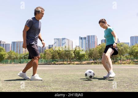 Couple d'âge mûr heureux jouant au football en plein air Banque D'Images