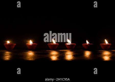 Groupe de diyas décorés sur fond noir pendant Diwali Banque D'Images