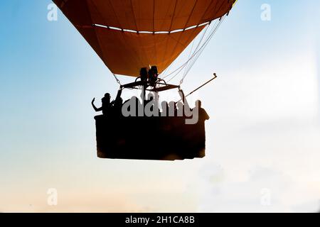 Gros plan d'un groupe de personnes qui se trouvent dans un ballon d'air chaud au premier plan et en contre-jour Banque D'Images