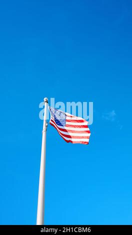 Drapeau américain contre le ciel bleu, espace pour le texte. Banque D'Images