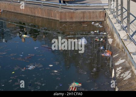 Vidnoe, Russie - 11 avril 2021 : pollution de l'étang de la ville après les vacances, beaucoup d'emballages de bouteilles flottent sur la surface de l'étang Banque D'Images