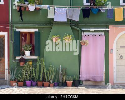 Vêtements suspendus sur la maison de façade peinte colorée sur l'île de burano Banque D'Images