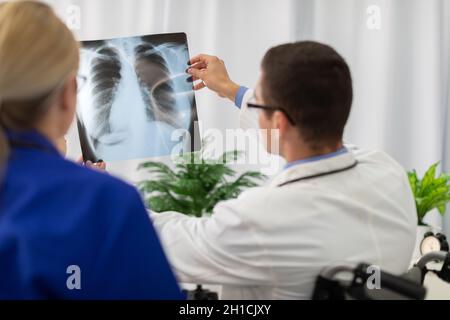 Un médecin et une infirmière regardent une photographie des poumons d'un patient. Banque D'Images