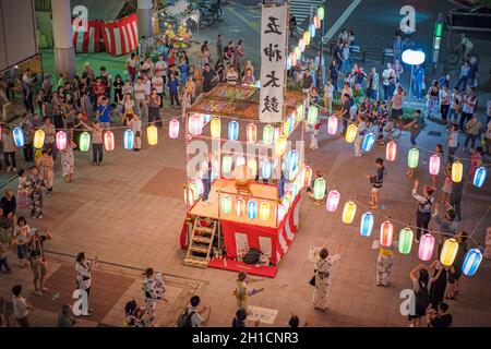 Vue sur la place en face de la gare de Nippori décorée pour le festival d'Obo avec des lanternes en papier illuminées dans la nuit d'été avec un y Banque D'Images