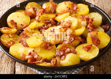 Pommes de terre frites ou Bratkartoffeln au bacon et à l'oignon, dans l'assiette de la table.Horizontale Banque D'Images