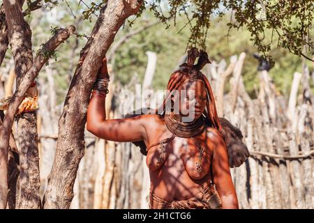 Namibie, KAMANJAB, 6 MAI: Ennuyer des femmes Himba dans le village posant aux touristes près de Kamanjab dans le nord de la Namibie, 6 mai 2018, Namibie Banque D'Images