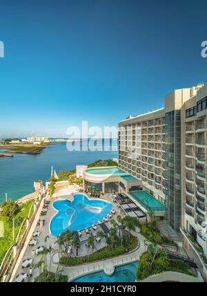 Ciel bleu d'été au-dessus de la piscine en forme de papillon de l'hôtel Loisir et de la mer du district de Sumiyoshi de Naha dans l'île d'Okinawa. Banque D'Images