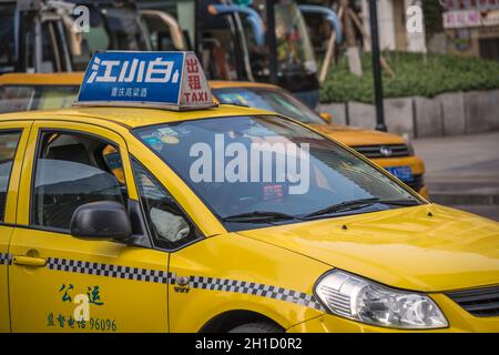 Chongqing, Chine - Août 2019 : taxi jaune en voiture sur la rue animée et encombrée Banque D'Images