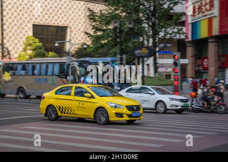 Chongqing, Chine - Août 2019 : taxi jaune en voiture sur la rue animée et encombrée Banque D'Images