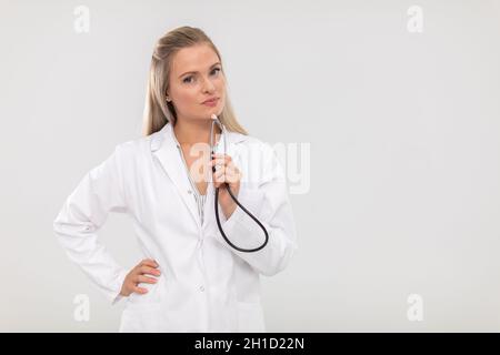 Le médecin regarde résolument dans la caméra et tient un stéthoscope dans sa main. Banque D'Images