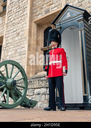 Londres, Royaume-Uni - avril 2019 : patrouille d'un soldat de garde anglais à Londres.Garde royale de Londres à un poste dans la Tour de Londres, se tient près du canon, Banque D'Images