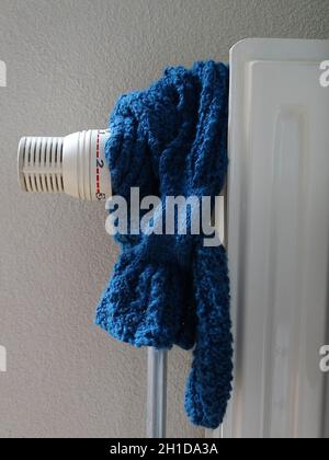 un foulard bleu autour du radiateur et du radiateur sur froid, presque fermé. prix élevés de l'énergie. hors du gaz. Banque D'Images