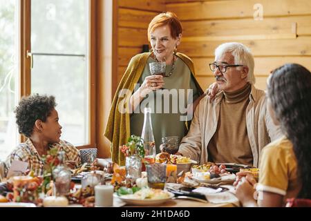 Grand-parent assis à la table à manger avec leurs petits-enfants et parlant pendant le dîner Banque D'Images
