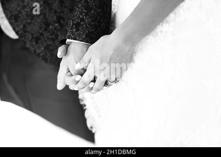 Détail des mains des époux après qu'ils ont échangé les anneaux de mariage dans l'église avec un détail de l'anneau de la mariée Banque D'Images