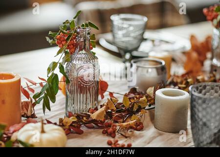 Gros plan de la table à manger avec un service magnifique sur elle décorée avec des branches d'automne Banque D'Images