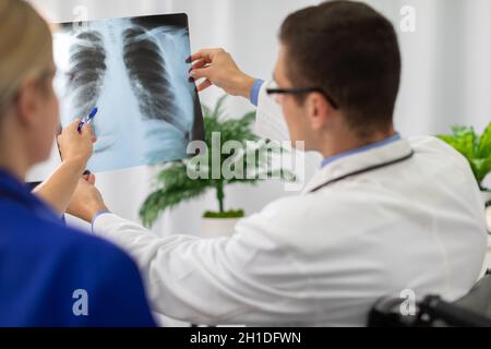 Un médecin et une infirmière regardent une photographie des poumons d'un patient. Banque D'Images