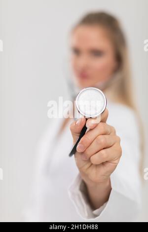 Le médecin tient un stéthoscope dans sa main tourné directement vers la caméra. Banque D'Images