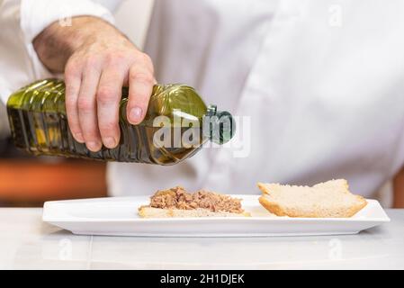 Chef pouring olive oil plus délicieux repas . Banque D'Images