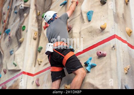 L'homme sportif pratiquant l'escalade à l'intérieur d'escalade . Banque D'Images