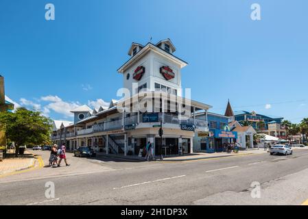 George Town, Grand Cayman Island, Royaume-Uni - 23 avril 2019: Vue sur la rue de George Town le jour avec des piétons près des cafés et des magasins touristiques dans le centre-ville de Banque D'Images