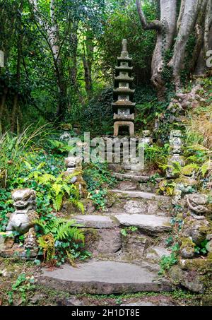 Une tour japonaise à plusieurs étages appelée pagode dans un jardin, avec des statues de lion.La pagode a une signification religieuse principalement liée au bouddhisme Banque D'Images