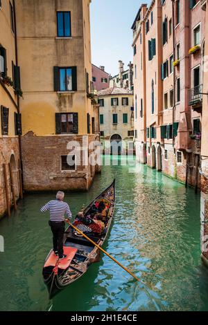 Venise, Italie - Avril 2018 : les touristes naviguant dans une gondole sur les beaux canaux de Venise en un jour au début du printemps Banque D'Images