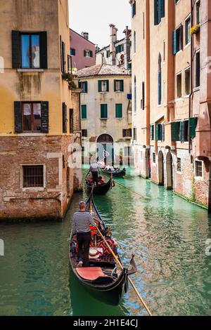 Venise, Italie - Avril 2018 : les touristes naviguant dans une gondole sur les beaux canaux de Venise en un jour au début du printemps Banque D'Images