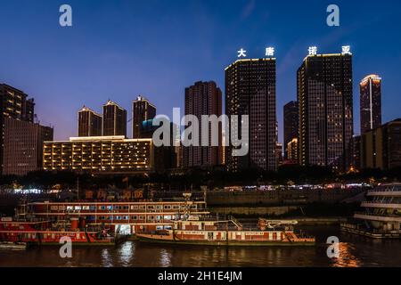 Chongqing, Chine - août 2019 : vue nocturne sur la ville de Chongqing illuminée sur la rivière Jialing et Yangtze avec bateau de luxe à passagers de croisière amarré sur t Banque D'Images