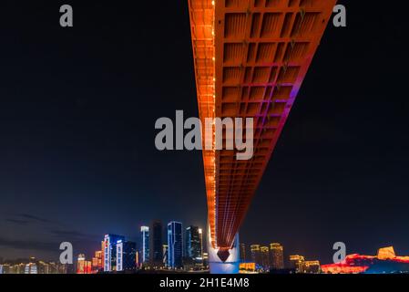 Chongqing, Chine - Août 2019 : pont routier éclairé DongShuiMen sur et en traversant la puissante rivière Yangtze Banque D'Images