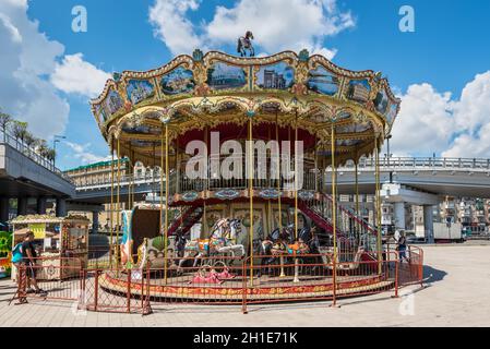 Kiev, Ukraine - le 13 juillet 2019 : Old vintage carousel attraction à la place de la poste à Kiev, Ukraine. Bateaux amarrés sur les rives du Dniepr. Banque D'Images