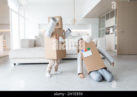 Les enfants gaies jouant dans le robot à la maison ayant du plaisir Banque D'Images