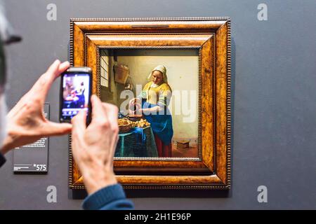 AMSTERDAM, PAYS-BAS - 12 MARS 2015 : Tourist prend une photo de téléphone portable de la peinture à l'huile de la Milkmaid par Johannes Vermeer à partir de 1658 Banque D'Images