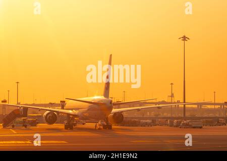 BANGKOK, THAÏLANDE-FÉVRIER 20, 2020 : avion stationné à l'aérodrome de l'aéroport avec ciel doré au lever du soleil. Concept de voyage d'été. Aviation et carg Banque D'Images