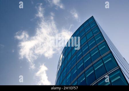 Partie de bâtiment moderne en verre et en acier se formant un ciel bleu profond avec des lignes Banque D'Images