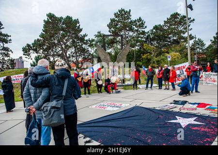 La Haye, pays-Bas.18 octobre 2021.Les manifestants se rassemblent tout en écoutant les discours pendant la manifestation.On voit des gens chiliens poser avec des drapeaux et des bannières contre le président chilien devant le bâtiment de la CPI.À l'occasion du deuxième anniversaire de l'épidémie sociale chilienne, les Chiliens vivant dans différentes villes européennes se sont rassemblés devant le bâtiment de la CPI (Cour pénale internationale) pour exiger le procès international de Piñera pour ses crimes contre l'humanité.Crédit : SOPA Images Limited/Alamy Live News Banque D'Images