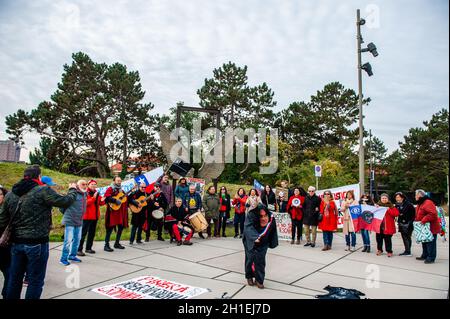 La Haye, pays-Bas.18 octobre 2021.Les manifestants se rassemblent tout en écoutant les discours pendant la manifestation.On voit des gens chiliens poser avec des drapeaux et des bannières contre le président chilien devant le bâtiment de la CPI.À l'occasion du deuxième anniversaire de l'épidémie sociale chilienne, les Chiliens vivant dans différentes villes européennes se sont rassemblés devant le bâtiment de la CPI (Cour pénale internationale) pour exiger le procès international de Piñera pour ses crimes contre l'humanité.Crédit : SOPA Images Limited/Alamy Live News Banque D'Images