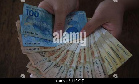 salvador, bahia / brésil - 28 mars 2020 : les mains des femmes détiennent des billets de banque reais, monnaie utilisée au Brésil. Banque D'Images