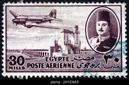 ÉGYPTE - VERS 1947 : un timbre imprimé en Égypte montre le roi Farouk, le barrage Delta et l'avion DC-3, vers 1947 Banque D'Images