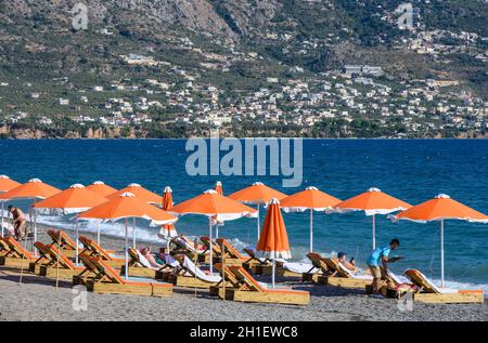 Chaises longues et parasols sur la plage à Kalamata, avec les montagnes Taygetos en arrière-plan, Kalamata, Messinia, Péloponnèse du Sud, Grèce, Banque D'Images