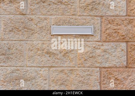 Boîte aux lettres blanche sur un mur de briques Banque D'Images