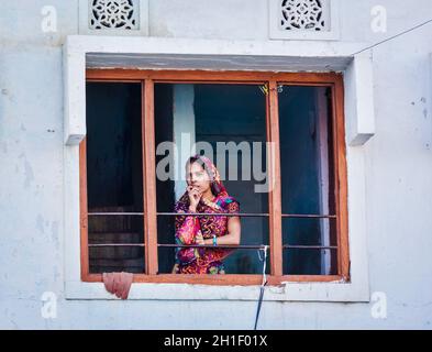 UDAIPUR, INDE - 24 NOVEMBRE 2012: Femme indienne dans le Rajasthani traditionnel tenue dans la fenêtre.Udaipur au Rajasthan est l'une des principales destinations touristiques Banque D'Images