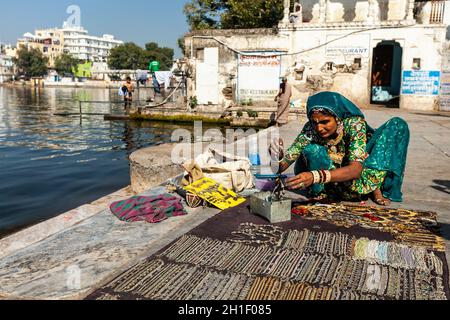 UDAIPUR, INDE - 24 NOVEMBRE 2012: Femme vendeur de rue dans les vêtements traditionnels vendant des bijoux sur le ghat du lac Pichola.Udaipur, Rajasthan, Inde Banque D'Images