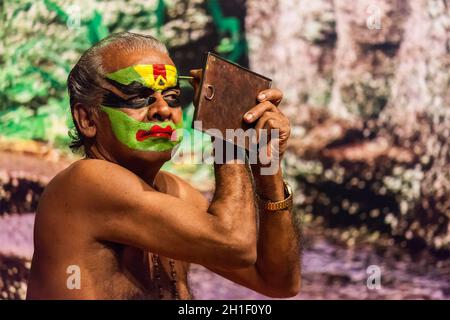 KOCHI, INDE - 24 FÉVRIER 2013 : exposant Kathakali non identifié se préparant à la performance en appliquant le maquillage de visage.Kathakali est la danse classique Banque D'Images