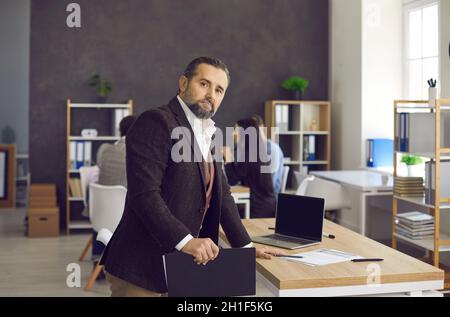 Portrait d'un cadre professionnel sérieux debout près d'un bureau dans un bureau moderne Banque D'Images