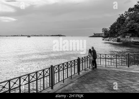 San Juan, Porto Rico - 30 avril 2019 : silhouette de coucher de soleil d'un couple de voyage sur la rive de la baie de San Juan, Porto Rico. Phot noir et blanc Banque D'Images